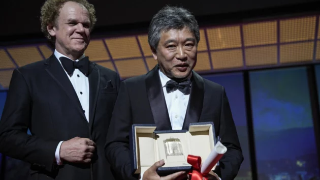 右の是枝裕和が、坂元裕二に代わって「モンスター」の最優秀脚本賞を受賞しています。授賞式で、左側にジョン・C・ライリーと。