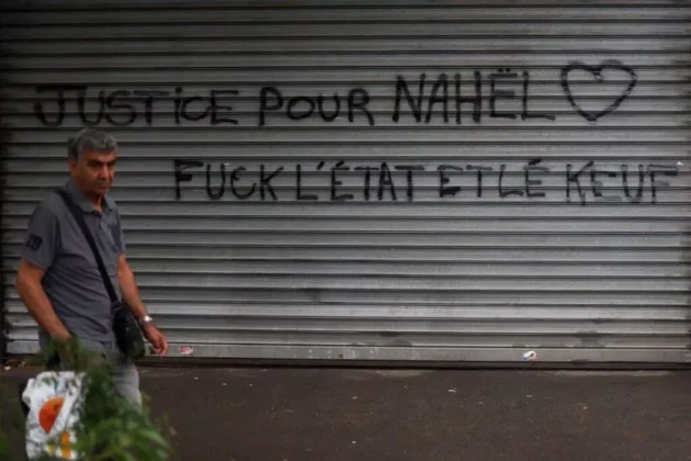 歩行者は、フランスでの4夜連続の暴動の後、2023年7月1日にナンテールのパブロ・ピカソ地区で「ナヘルの正義、国家と警察をファック」と書かれたメッセージで店のシャッターを通り過ぎます。 歩行者は、フランスでの4夜連続の暴動の後、2023年7月1日にナンテールのパブロ・ピカソ地区で「ナヘルの正義、国家と警察をファック」と書かれたメッセージで店のシャッターを通り過ぎます。AFP - チャーリー・トリバロー