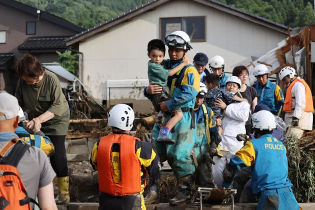 救助隊員は、南西日本の洪水や地滑りに巻き込まれた家族を救出するのを助けました © STR / JIJI Press/AFP