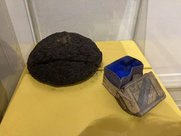 今日最も一般的に使用されている合成バージョンの横にあるインドからの生のインディゴのボール(左)で、ミュゼ・デュ・ヴュー・ニームで展示されています。© Hird/RFI 