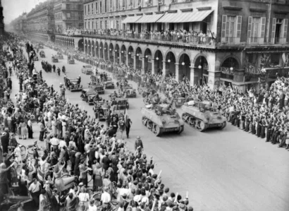 群衆は、パリ解放の翌日の1944年8月26日にリヴォリ通りをパレードするフランス内務軍(FFI)のメンバーとルクレール師団の戦車に挨拶します。© AFP