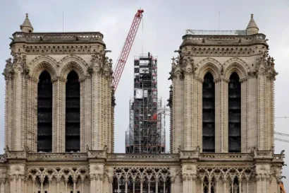 2023年12月6日、ノートルダム大聖堂大聖堂の再建作業中、作業員は新しく再建された尖塔の上に立ち、十字架を置きます。© AFP - ルドヴィッチ・マリン