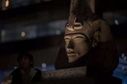 2025年2月7日、ギザの大エジプト博物館を見学しているときに、古代エジプト王アケナテンの胸像の近くを歩いている訪問者。© AFP - カレド・デスーキ