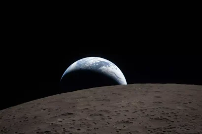この配布画像は、NASAが2026年4月7日に公開したもので、地球が月の地平線（別名「アースセット」）を越えて沈み出す様子を、2026年4月6日にオリオン宇宙船から撮影したものです © Handout / NASA/AFP