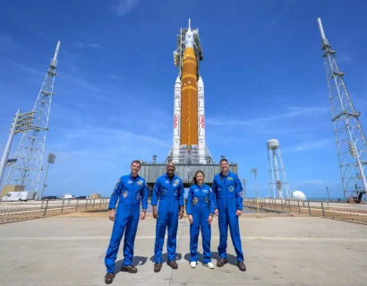 NASAの宇宙飛行士リード・ワイズマン（アルテミスII司令官）左、ヴィクター・グローバー（アルテミスIIパイロット）、クリスティーナ・コッホ（アルテミスIIミッションスペシャリスト）、CSA（カナダ宇宙局）宇宙飛行士ジェレミー・ハンセン（右）が、NASAのアルテミスII（Space Launch System）ロケットとオリオン宇宙船を訪問する様子が、2026年3月30日月曜日にフロリダ州ケープカナベラルにあるNASAケネディ宇宙センターのローンチコンプレックス39Bで撮影されたグループ写真です。AP - ビル・イングァルズ